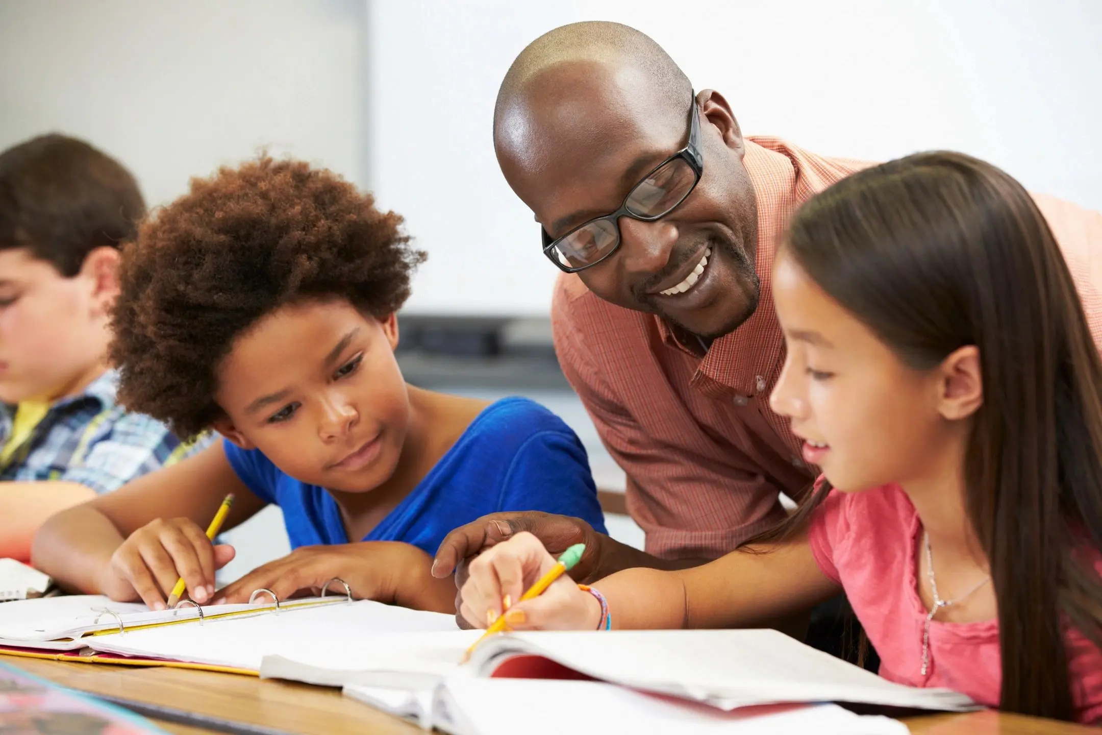 A man and two children are doing homework.